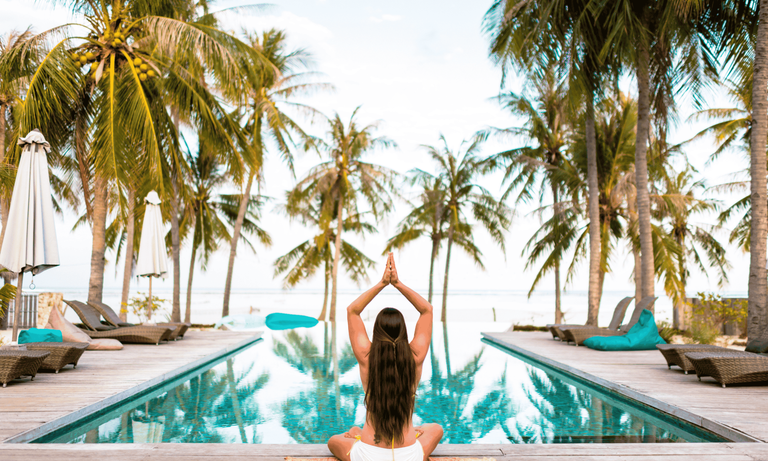 Traveler doing a yoga pose infront of a pool 