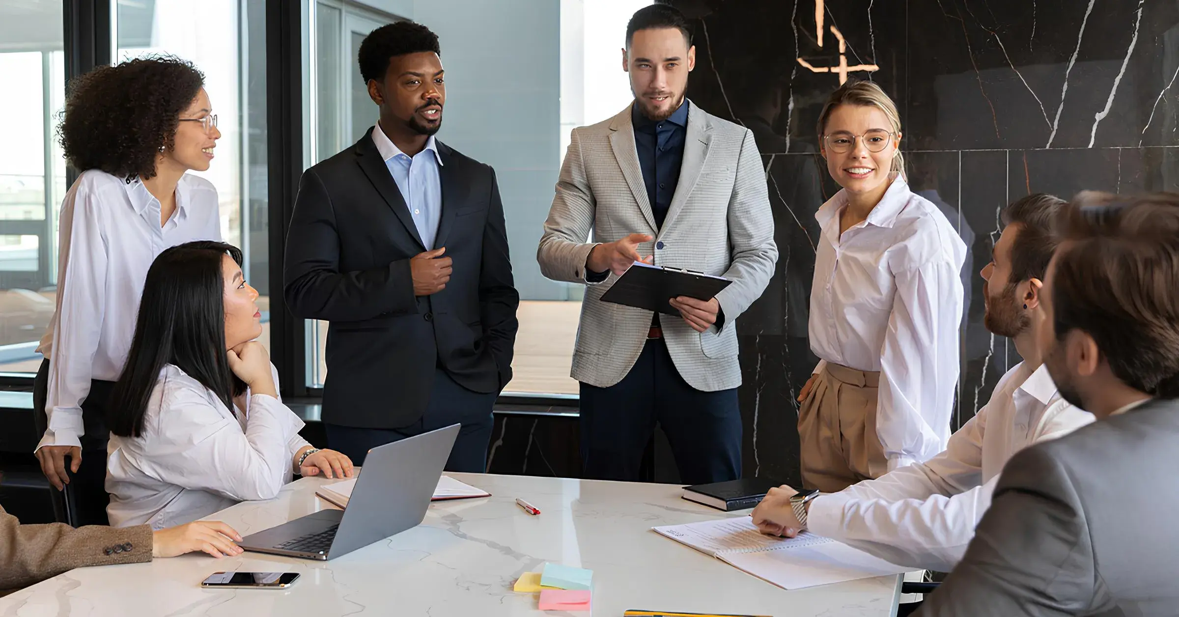 A diverse corporate team collaborating and discussing strategy during a meeting in a modern conference room.