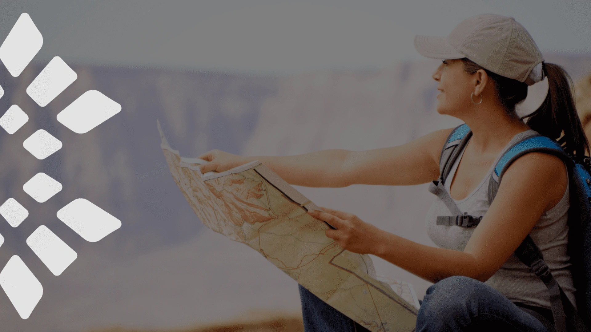 Traveler with a backpack reading a map while exploring a scenic canyon landscape