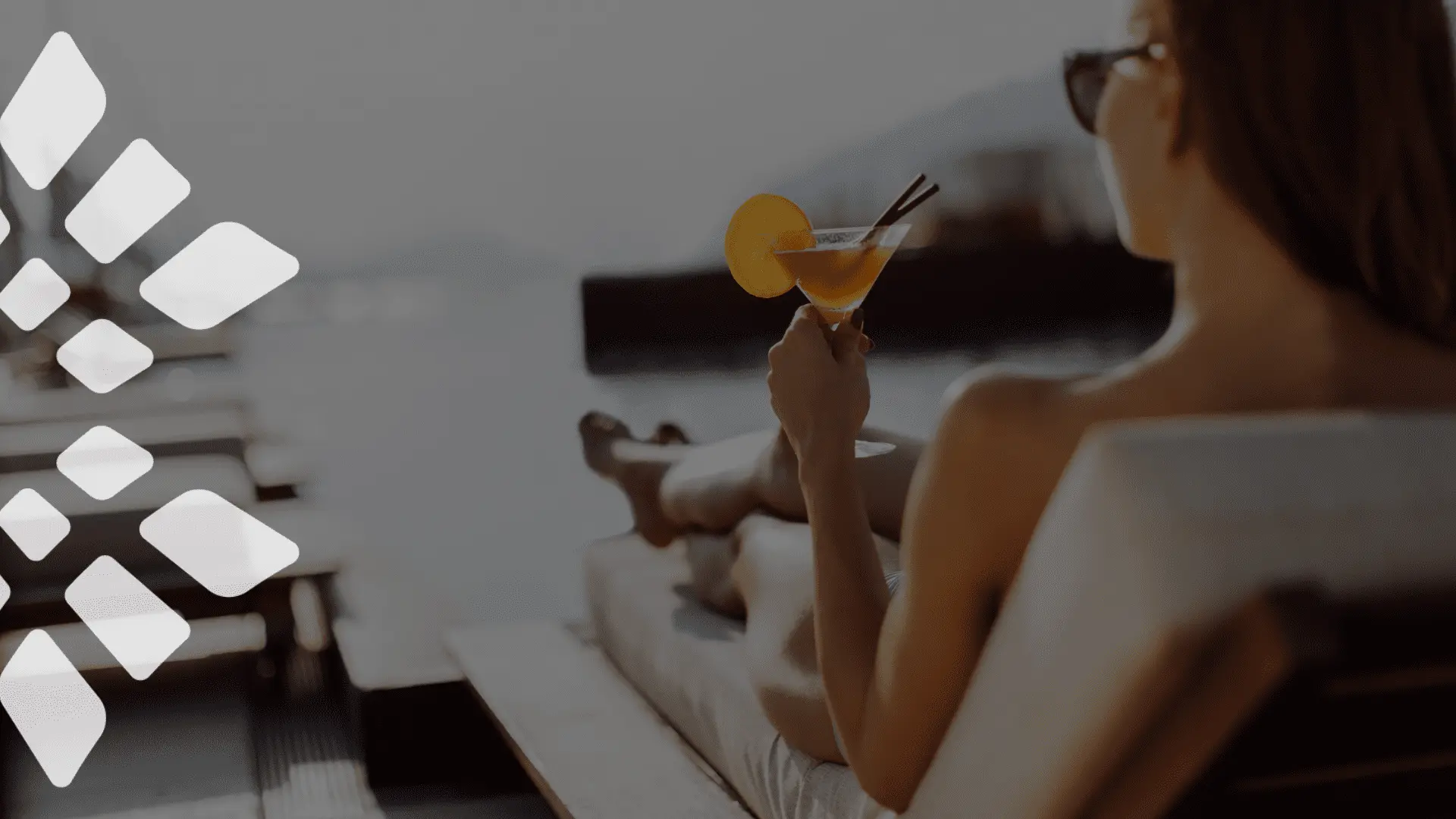 Woman relaxing at a luxury resort while enjoying a tropical drink with an oceanfront view